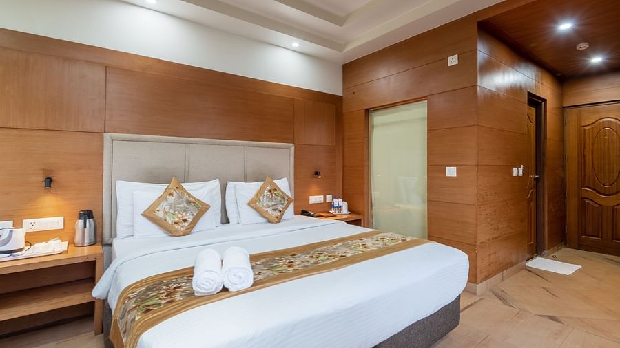 A bedroom featuring a king size bed, and a table with bottled water and a glass at DLS Hotels The Rock Castle.